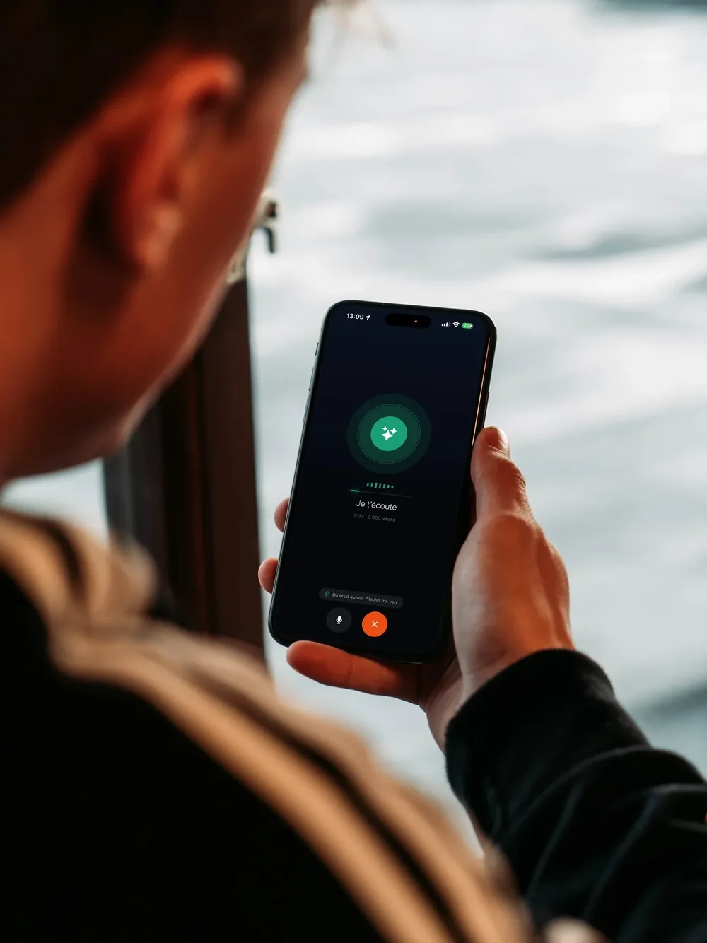 A person holds a smartphone showing Gillia's voice screen: “I'm listening.”