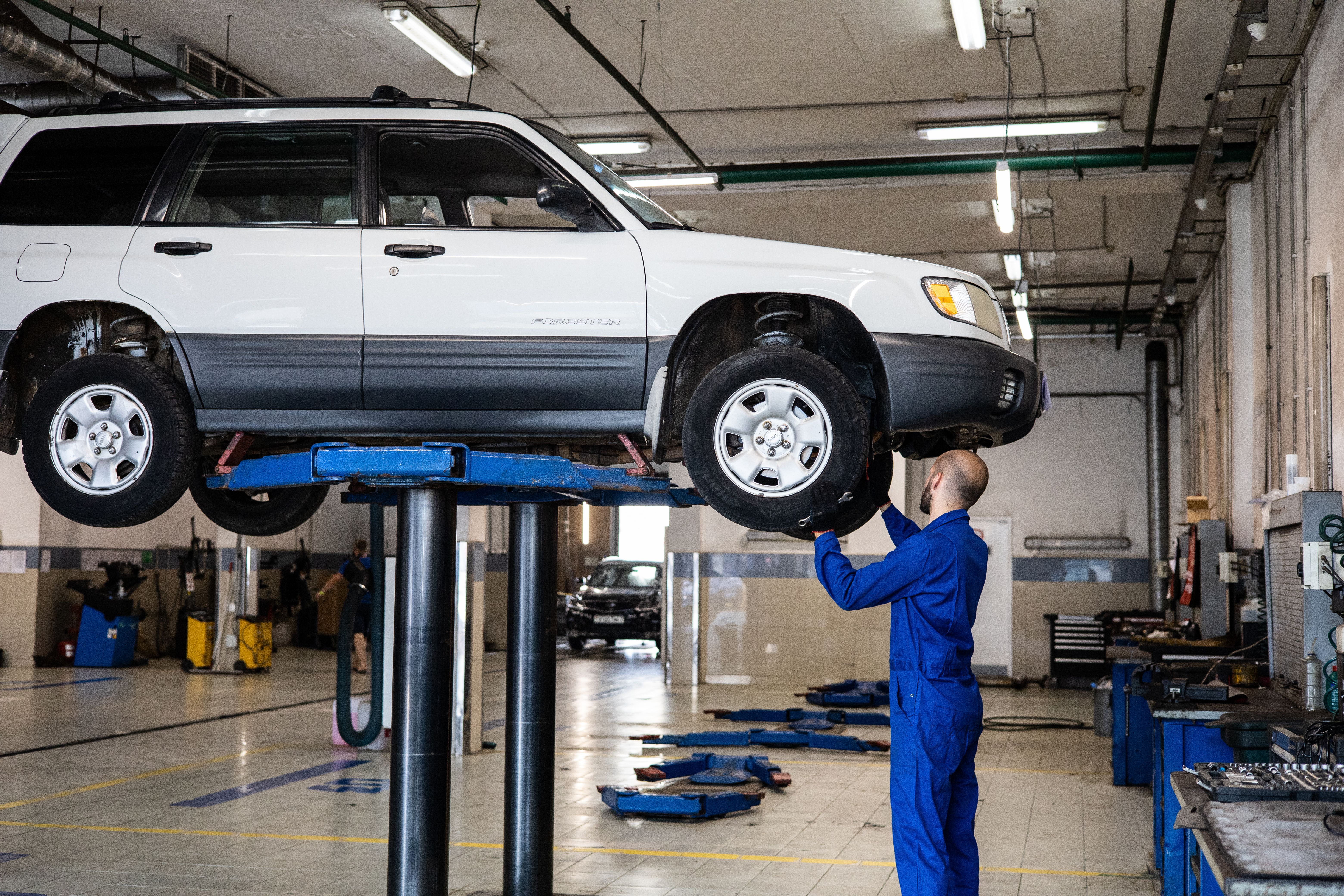Mechanic inspecting a vehicle on a lift in a garage